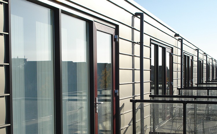 Donkere kozijnen en glazen deuren aan de buitenzijde van een gebouw